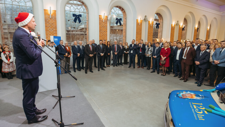 Zgromadzenie w&nbsp;sali goście na&nbsp;spotkaniu wigilijnym słuchają przemówienia. Na&nbsp;scenie mężczyzna mówi do&nbsp;mikrofonu. Widać maskę  fita 125 p