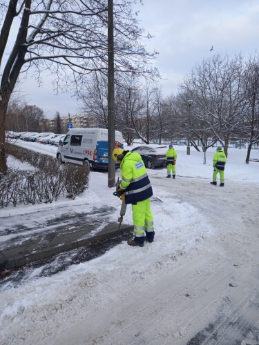 W zimowej aurze, pracownik pogotowia wodociągowego za pomocą młota pnematycznego robi dziurę w jezdni by dostać się do wodociągu.
