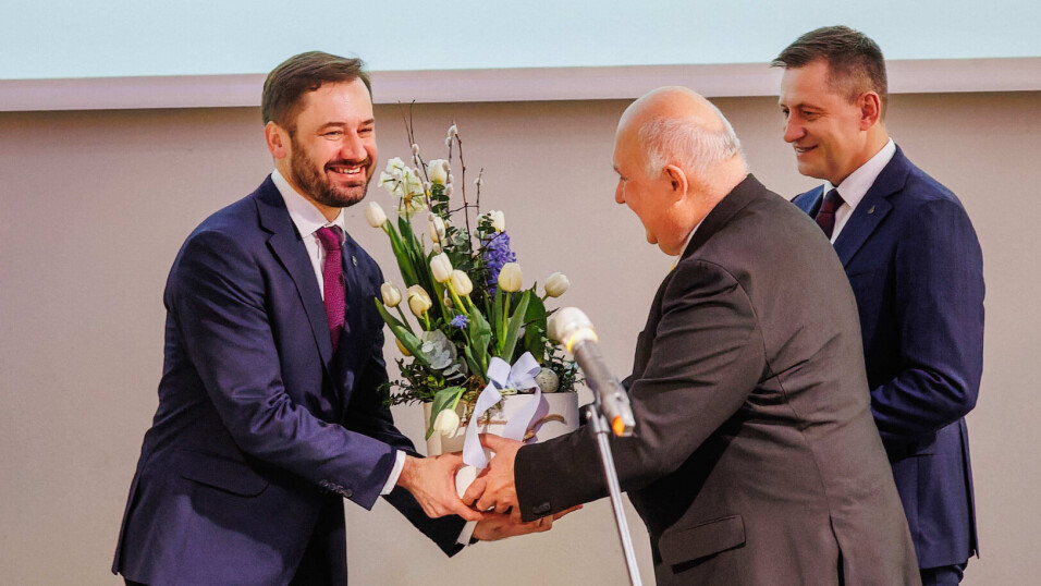 rzech mężczyzn stoi na&nbsp;scenie. jeden z&nbsp;nich ma wręczany stroik świąteczny jest to&nbsp;Prezydent Krakowa.