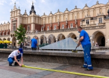 Pracownicy wodociągów czyszczą fonannę na Rynku Głównym