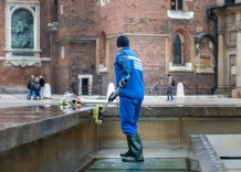 Pracownik Wodociągów Miasta Krakowa czyści fontannę na Rynku Głównym