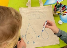 Dzieci rysują na torbie płóciennej.