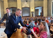 Wiceprezydent Krakowa wręczający plecak dziewczynce