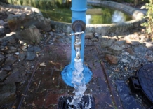 Hydrant z pokrętłem. Lejąca się woda. 